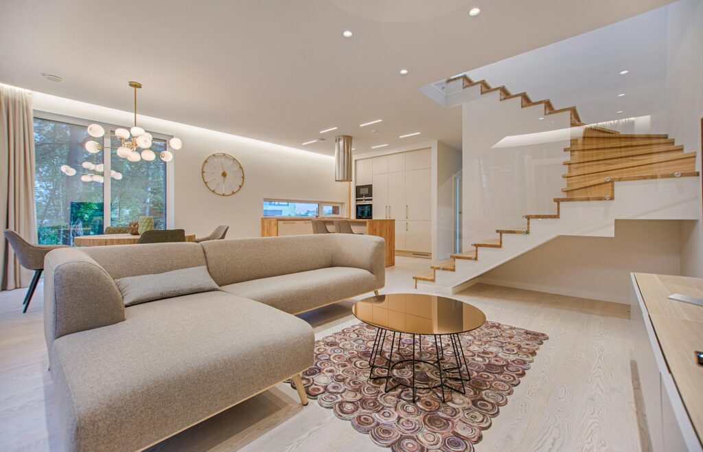 pexels-photo-1571460-1571460 Contemporary living room with neutral tones, a sleek sofa, and elegant wooden staircase.